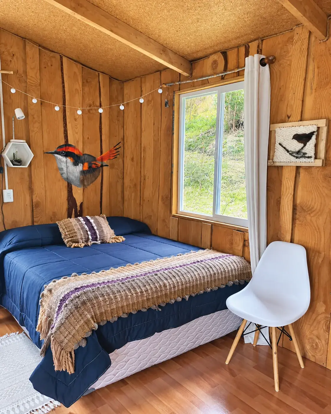 Dormitorio de Oregon con cama, ventana y muro de madera
