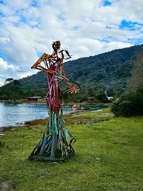 Figura decorativa de colores sobre el césped, junto al agua y las montañas