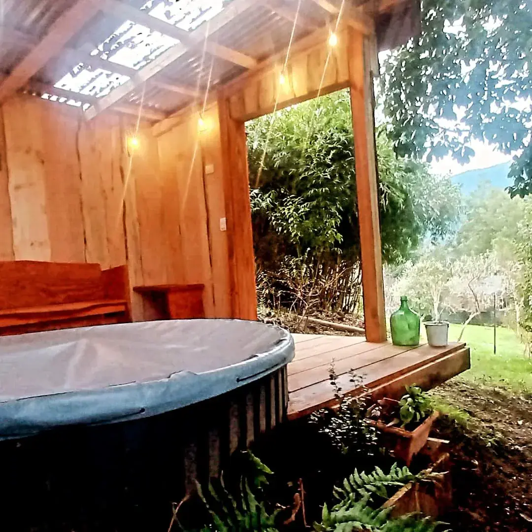 Tina exterior de Eco Cabañas Quilanto en una terraza de madera junto al bosque